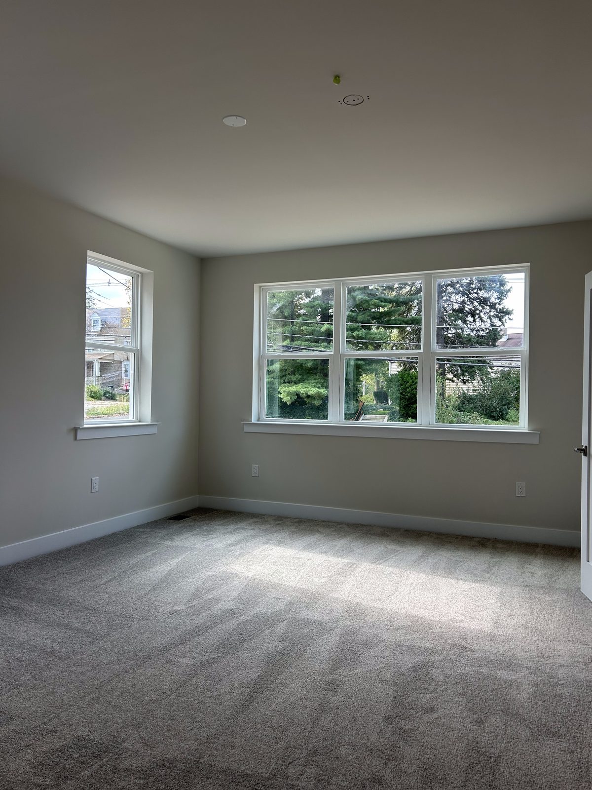 Model 1 primary bedroom, unfurnished, with two windows