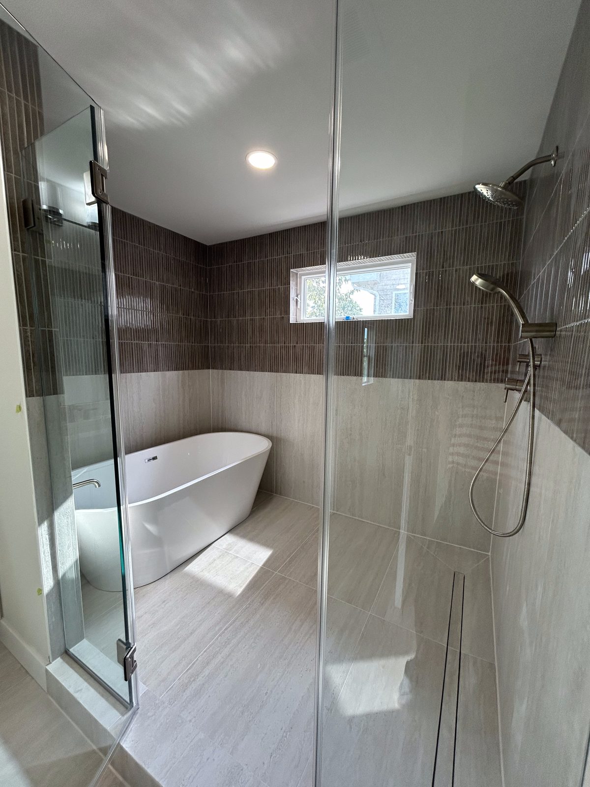 Model 1 primary bathroom freestanding soaking tub and glass shower enclosure