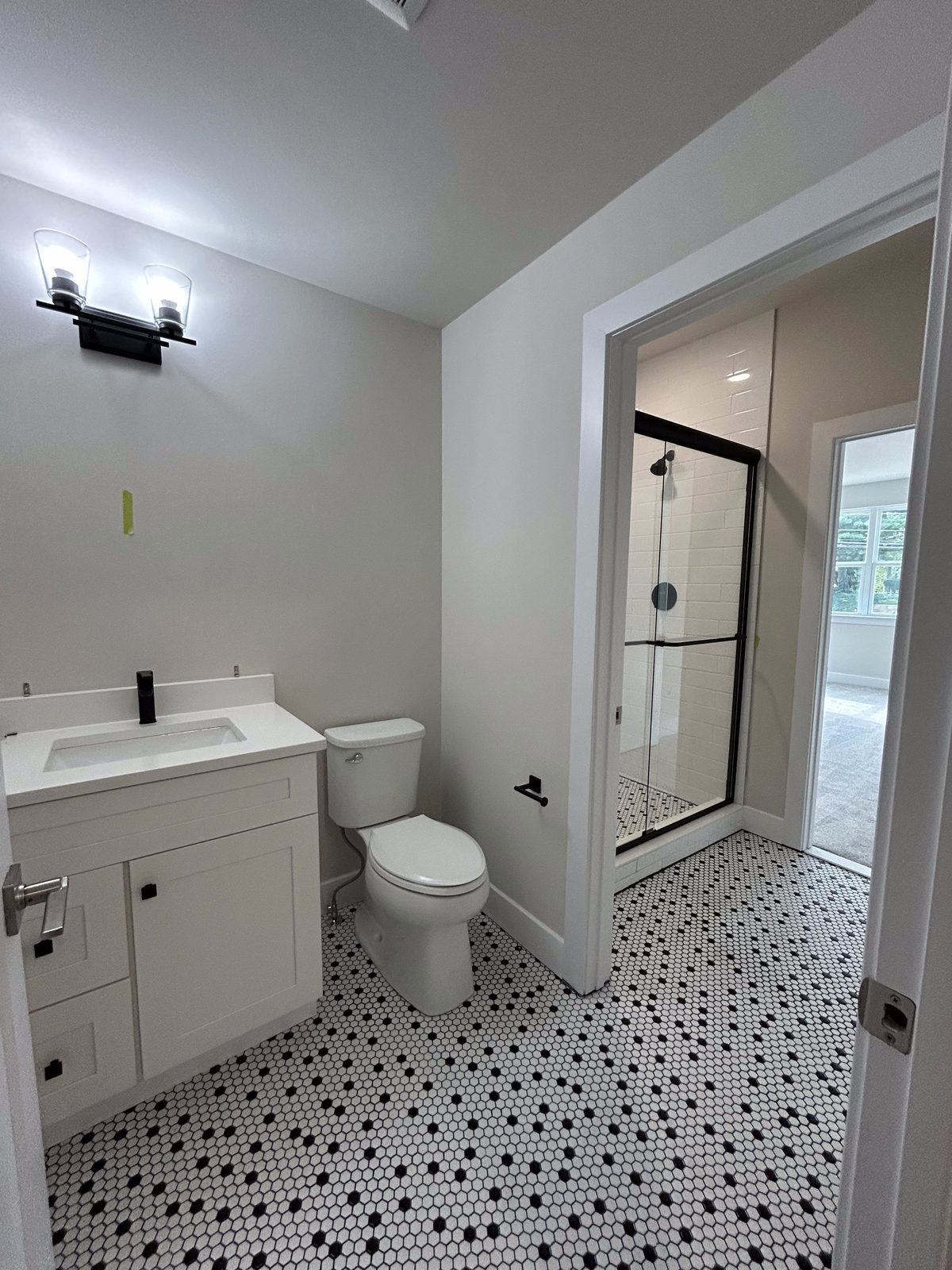 Model 1 guest suite bathroom vanity and toilet with patterned tile floor