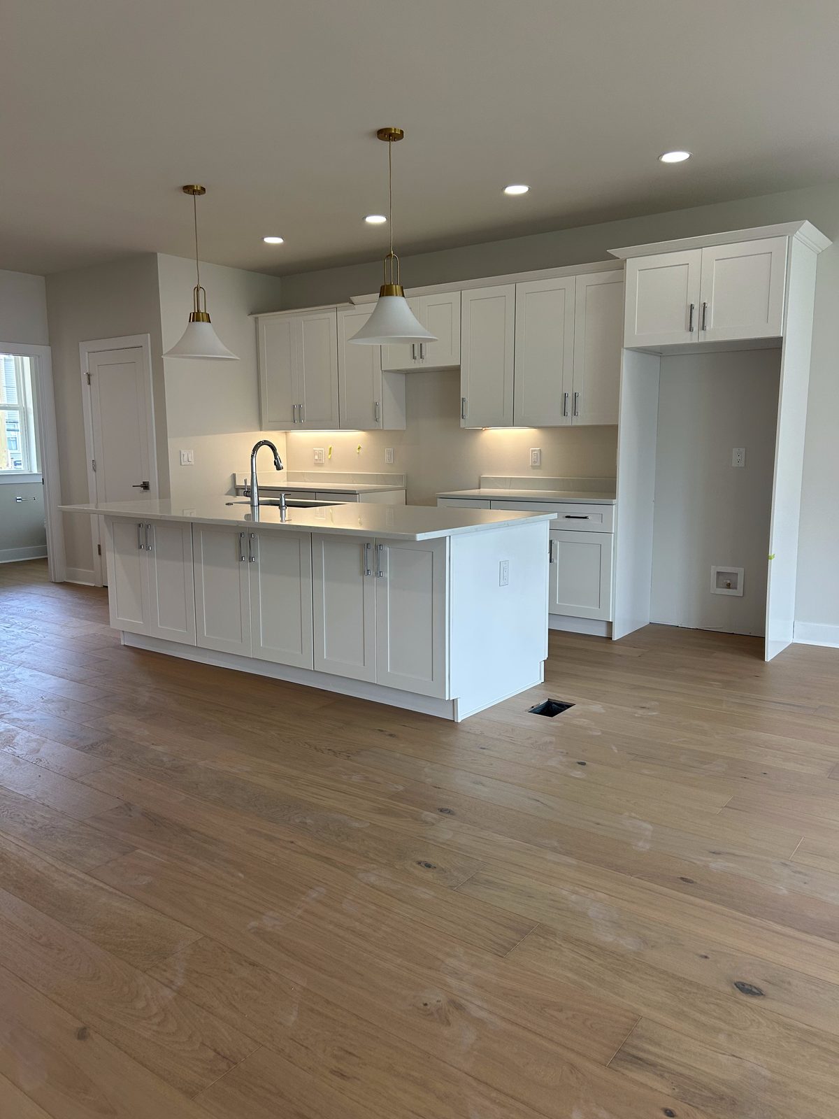 Model 2 kitchen with white cabinets, island, and pendant lighting