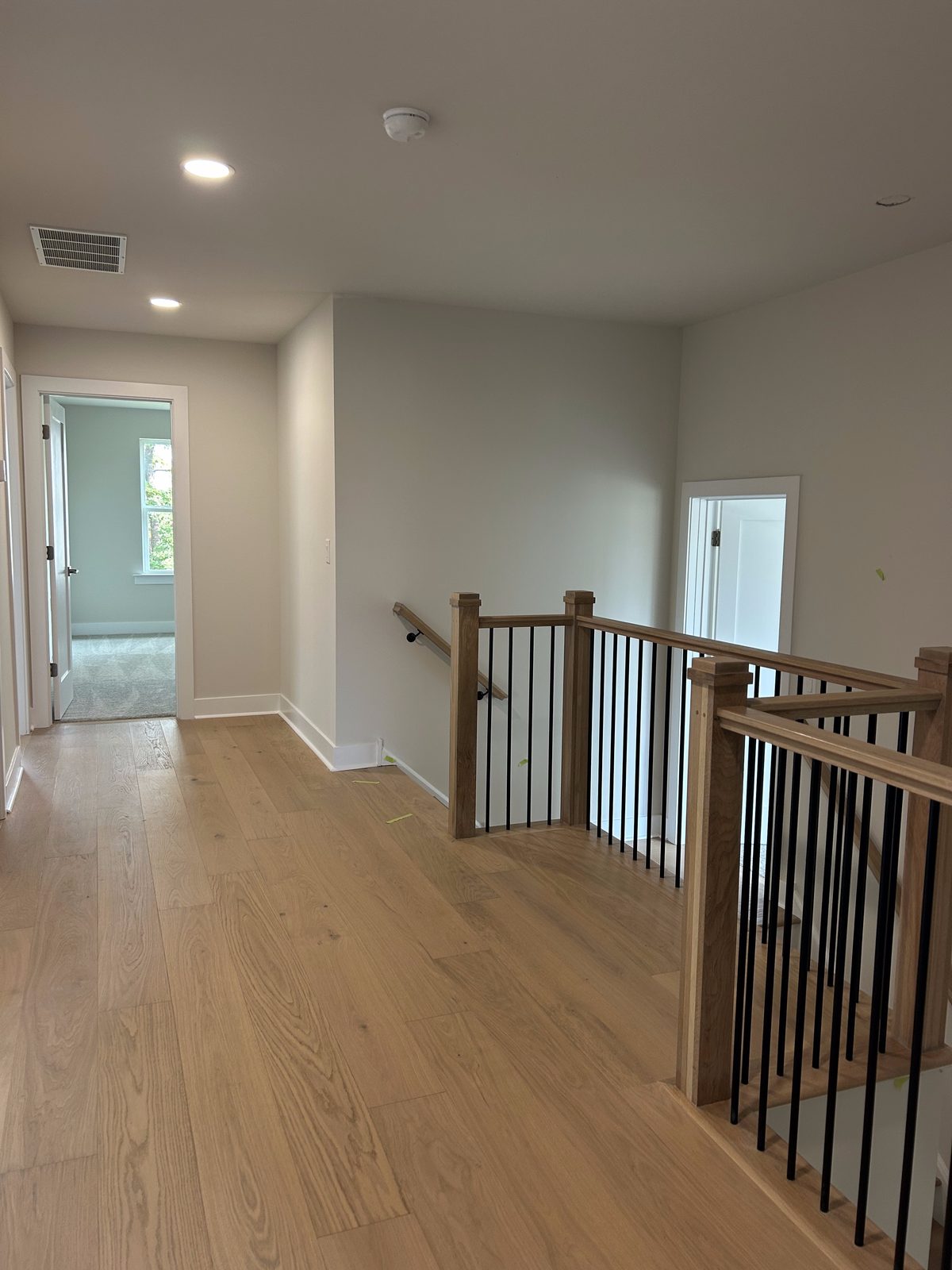 Model 2 upstairs hallway with wood flooring and railing