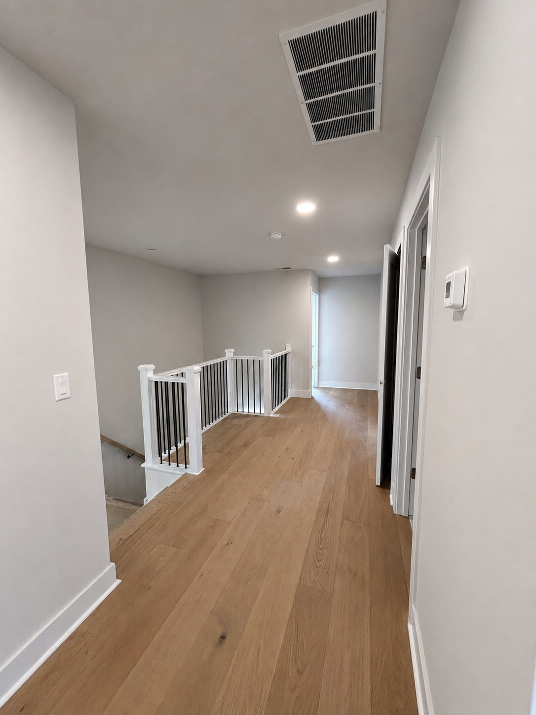 Model 2 upstairs hallway with white oak flooring and painted railing