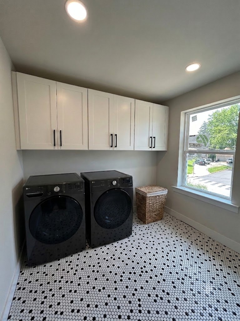 Model 2 laundry room with white cabinetry, front-load washer and dryer, and hexagon tile floor